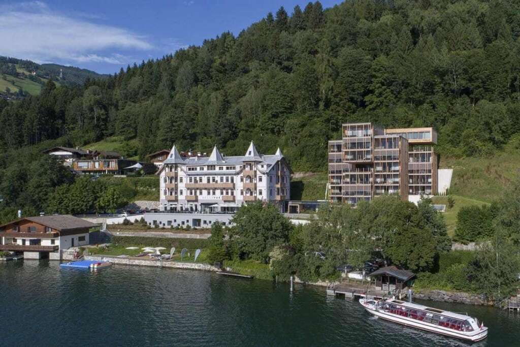 Historisches Hotel am Seeufer, umgeben von Wald