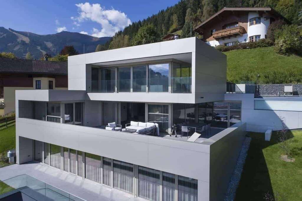 Modernes weißes Wohnhaus mit großen Glasflächen am Berghang